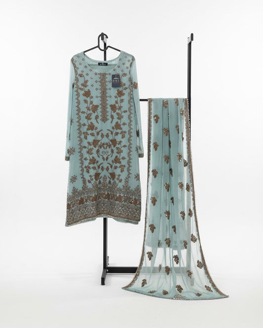 Pakistani 3 piece stitched suit in seafoam blue featuring embroidered kameez with gold detailing, sheer net dupatta with embroidered motifs, and matching trousers displayed on a clothing stand
